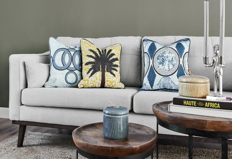Set van twee ronde houten salontafels voor een grijze bank