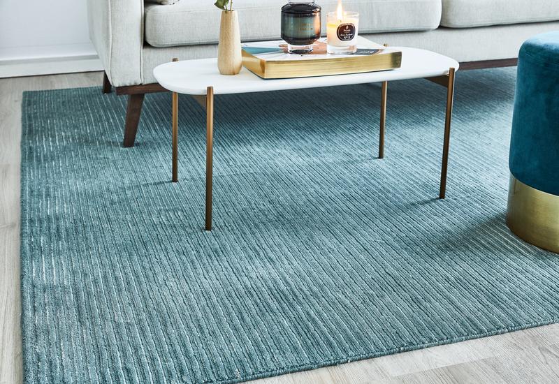 Witte ovale salontafel op blauw vloerkleed