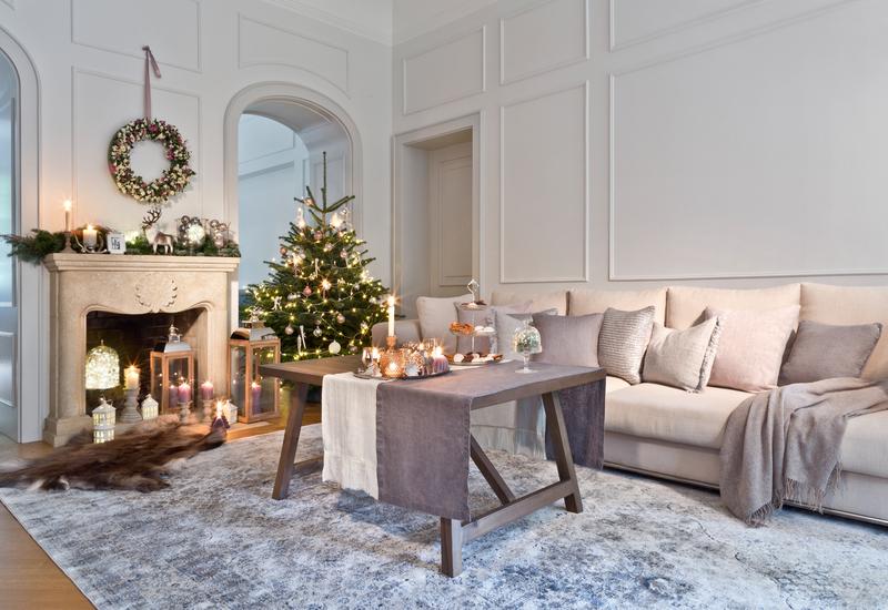 Kerstboom met lampjes en versiering in een woonkamer