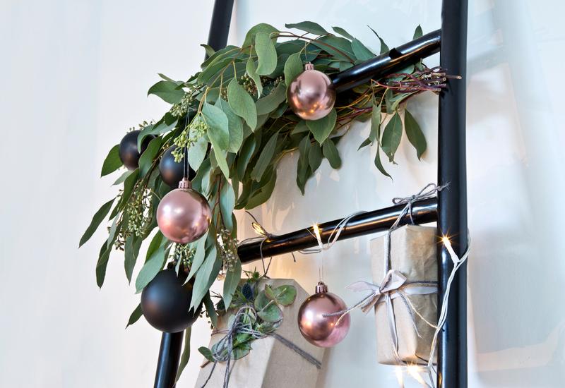 Onbreekbare kerstballen aan een zwarte decoratieve trap