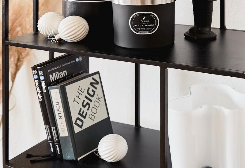 Witte kerstballen in een boekenrek