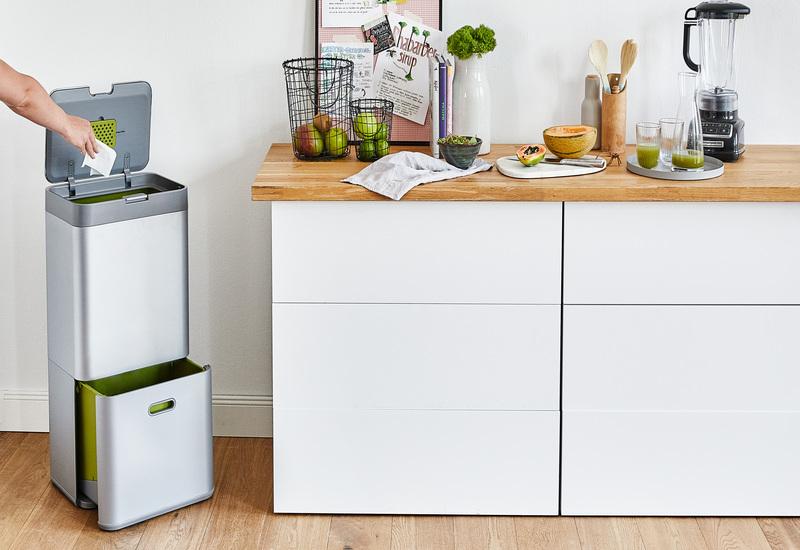 witte keuken met vuilnisbak en keukenapparatuur Boheemse witte keuken met houten accenten en een vloerkleed