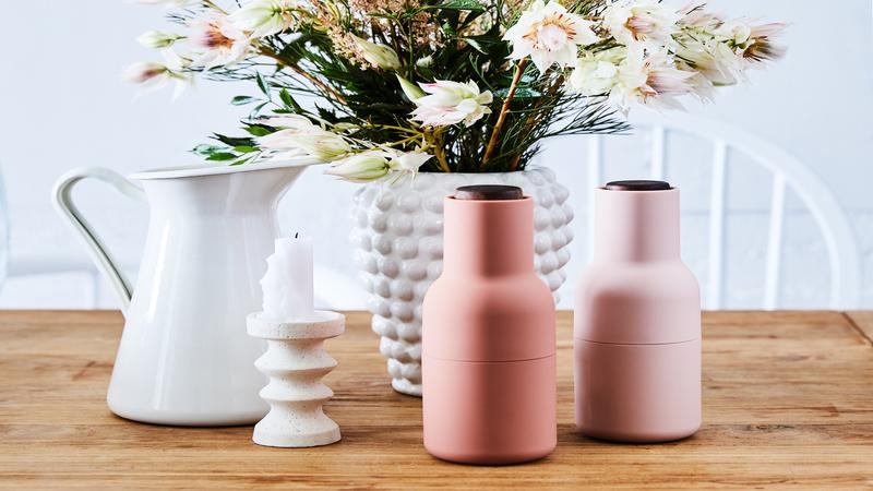 roze peper en zoutmolen op tafel met bloemen