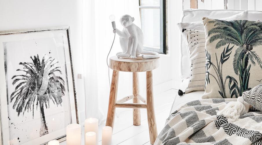 witte aap lamp op een houten kruk naast een bed