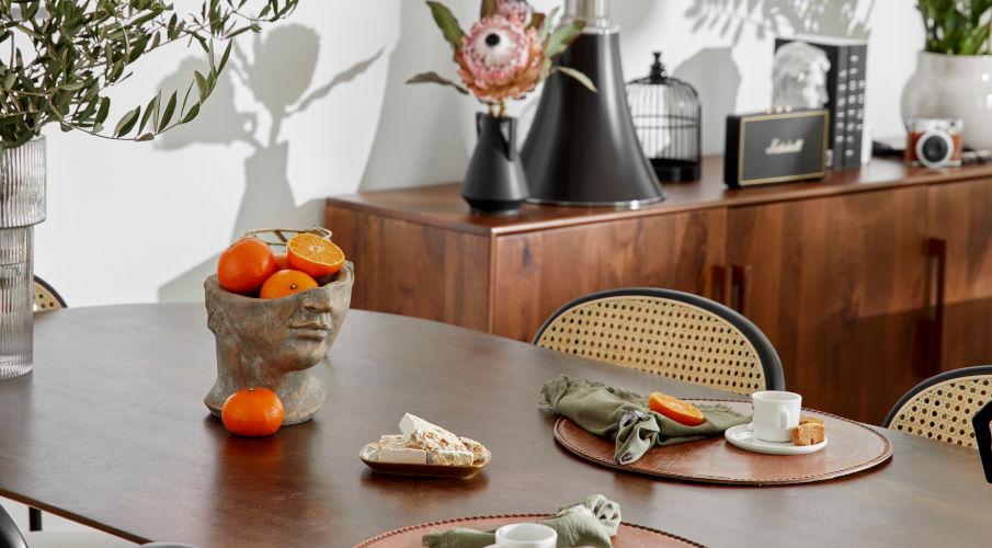 bloempot gezicht met sinaasappels op een houten tafel