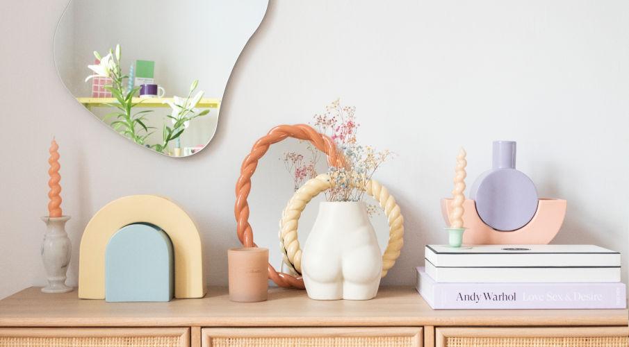 assymetrische spiegel met pastel decoratie en gedraaide kaarsen