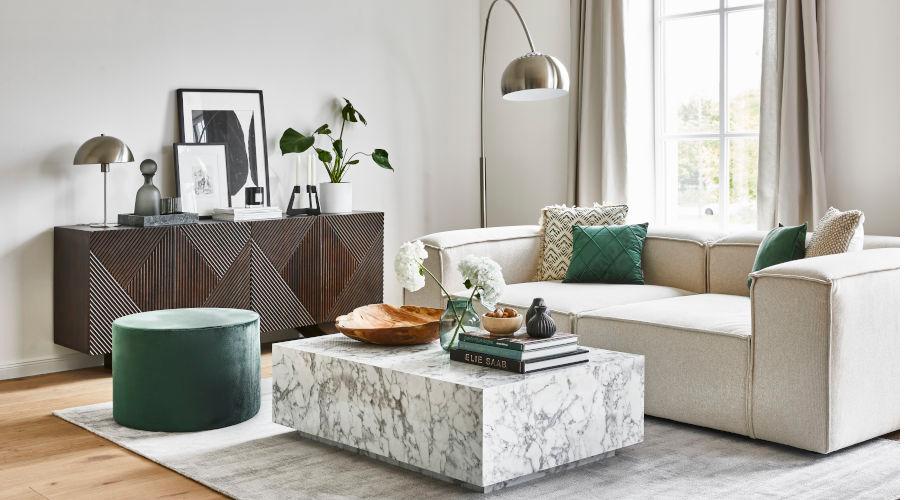 een woonkamer met bank, salontafel, dressoir en een mushroom lamp