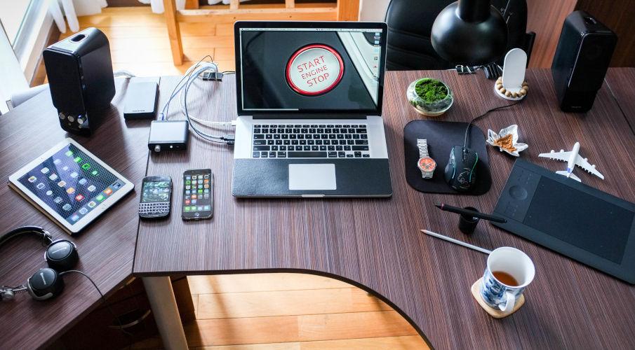 Hoekbureau in donker hout met een laptop en ipad erop