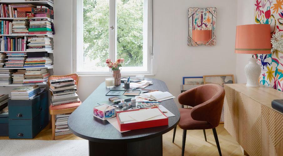 modern bureau in zwart met schilderspullen en een bruine stoel