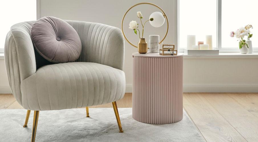Bijzettafel modern in roze naast een grijze fauteuil