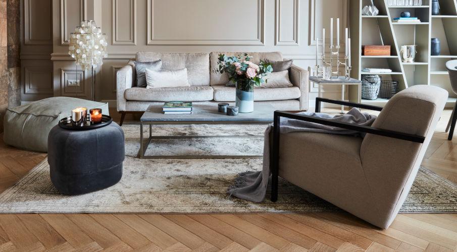 Poef grijs en grijze bank en stoelen in een klassiek interieur