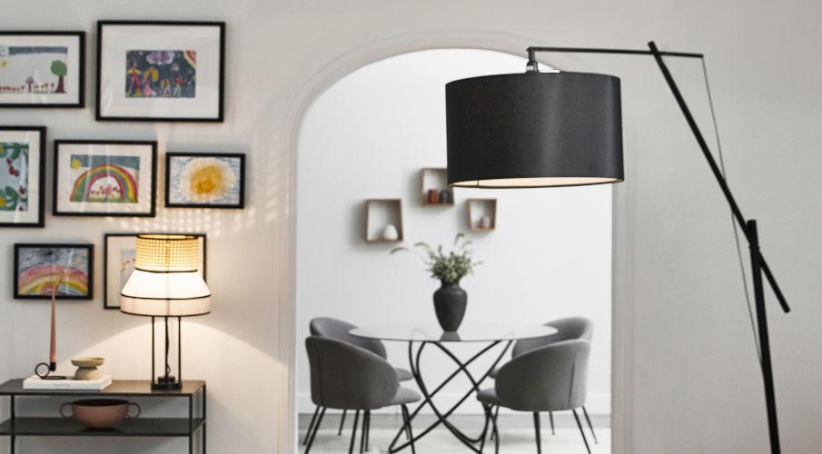 Tomasucci meubels in een eetkamer met zwarte lamp, tafel en stoelen die naast een gallarywall staan