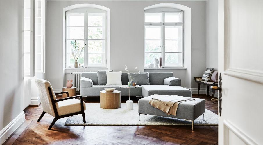 salontafel blok rond hout in een modern interieur met grijze bank, houten stoen en witte muren