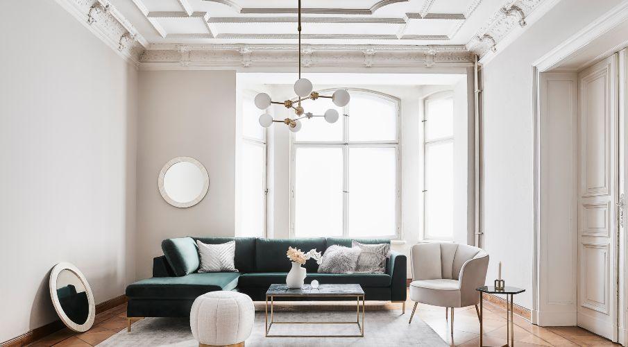 ronde fauteuil in een moderne woonkamer met witte muren en een groene bank
