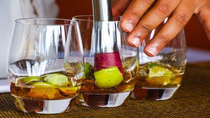 Szklanki do drinków Osoba przygotowuje drink z kawałkami owoców