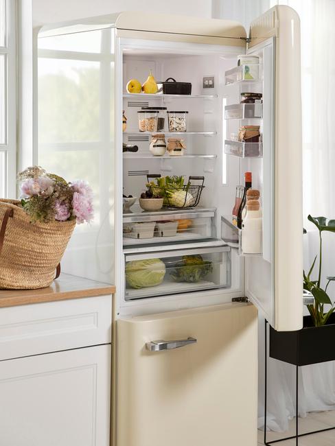 Geöffneter Kühlschrank mit Lebensmitteln in beige