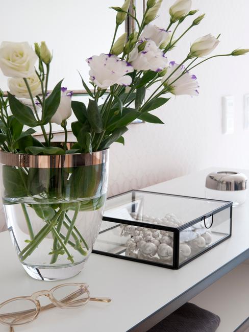bruiloftsspeech-7 Boeket voorjaarsbloemen in een vaas naast glazen opbergdoos op witte sidetable bij het schrijven van de speech bruiloft