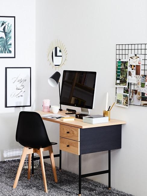 Arbeitsplatz in schwarz und hellem Holz mit Wandbildern und Pinnwand