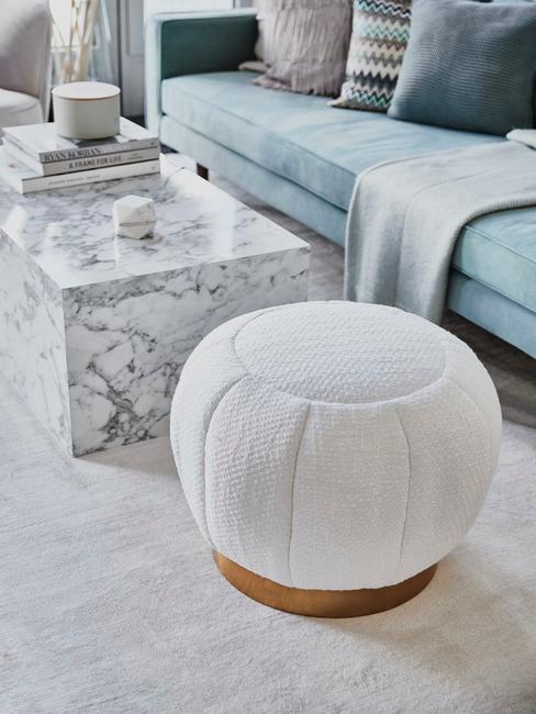 Salñon avec grand bloc en marbre blanc comme table basse devant un pouf blanc et un canapé