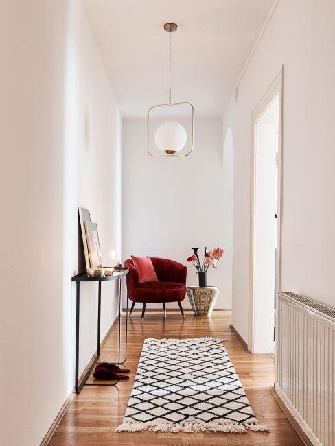 Éclairage intérieur avec lampe supsendue et murs en couleur crème, tapis long sur sol en parquet dans un large couloir