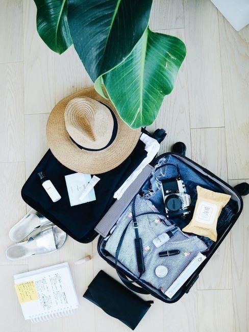 valigia aperta con accessori da viaggio e vestiti