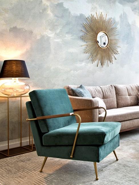 Divano e poltrona davanti ad una parete con carta da parati a chiazze in blu-grigio