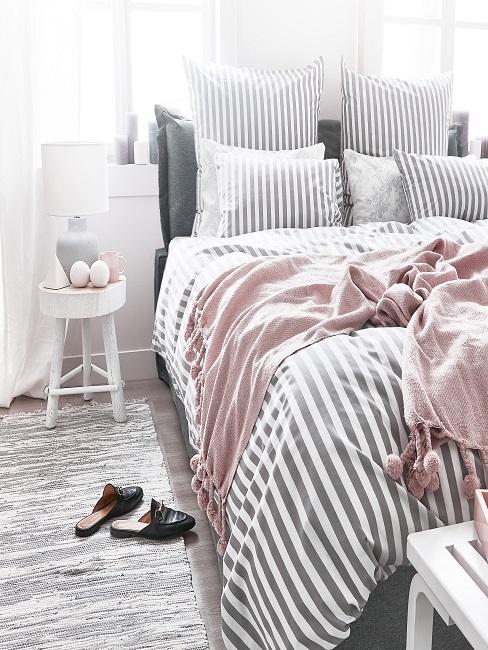 Schlafzimmer mit grau-weiß gestreifter Bettwäsche