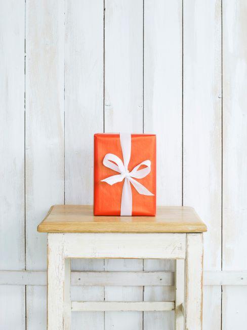 Cadeau d’anniversaire Cadeau dans un emballage orange sur tabouret rustique