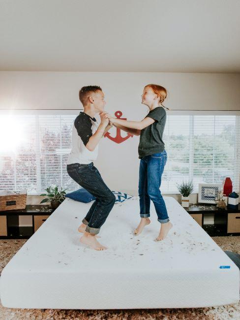 matelas-pour-enfant fille et garçon sautent sur un matelas