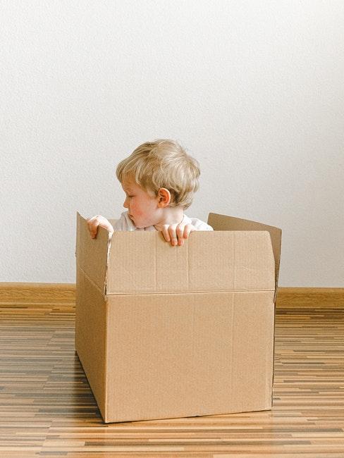 Livraison à domicile Petit garçon assis dans un carton