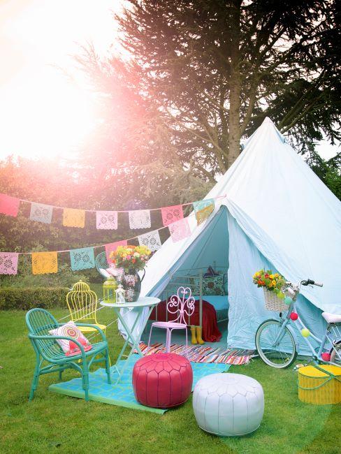 Glamping Tente blanche sur gazon vert, détails déco de couleurs vives et pastel