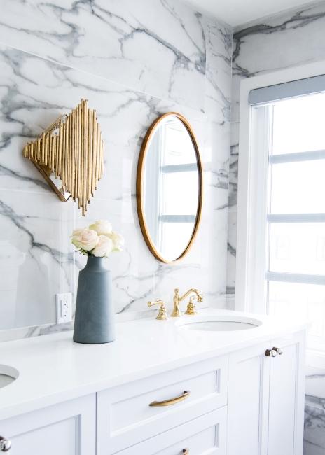 Salle de bain luxueuse avec miroir doré et mur en marbre