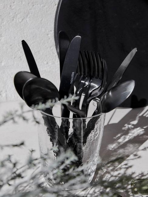 Header zilver schoonmaken Zilver bestek in glas op aanrecht in zwart wit