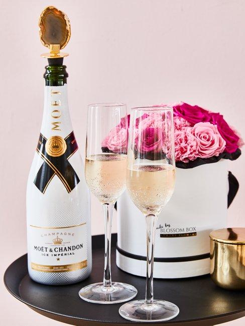 Gouden bruiloft Header Moet champagne inclusief glazen op zwarte ronde tafel met roze rozen in ronde doos als verlovingscadeau