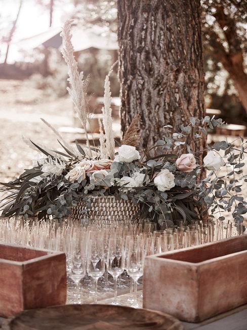 Bruiloftsspeech Heading Speech bruiloft champagne glazen buiten op houten tafel met bruidsboeket
