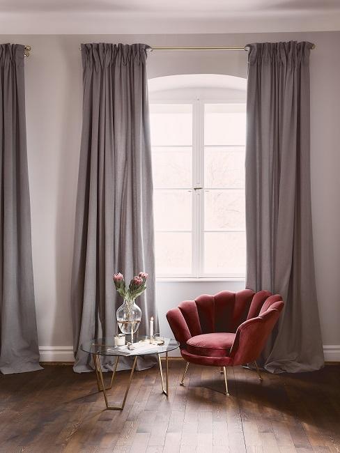 De kleurengids: Welke kleur past bij oud rood?-2 Bordeauxrode fauteuil met glazen bijzettafel en boeket in glazen vaas