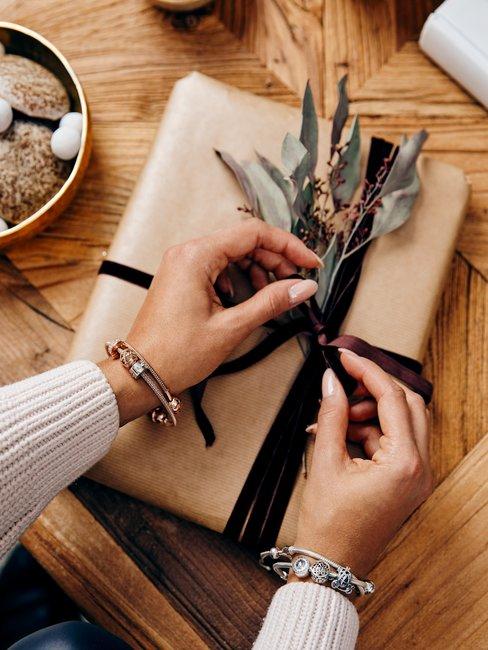 Valentijnscadeau voor hem 3 Cadeau verpakking met strik en handen op houten tafel