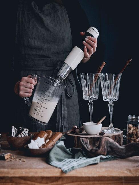 Voorgerechten kerst header Keuken voorgerechten kerst in kristallen wijnglazen met chefkok in grijze koksbuis op houten tafel