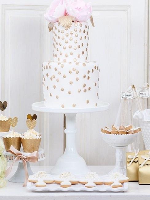 Hochzeitstorte mit goldenen Punkten auf hohem Etagere