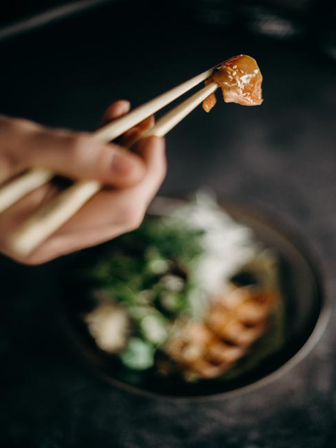 Osoba jedząca sushi pałeczkami
