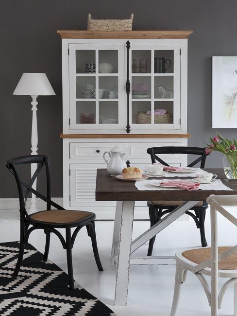 Kleines Esszimmer einrichten mit schwarz-weißen Stühlen, Tisch, Teppich und Vitrine