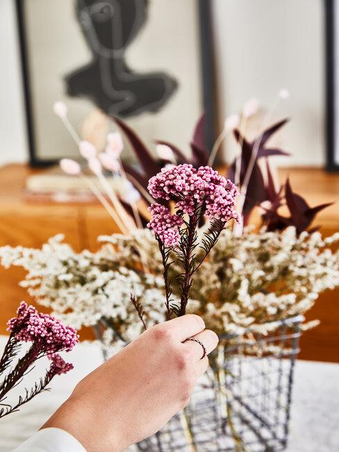 mano coloca una flor artificial en ramo