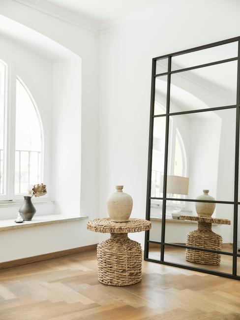 Feng shui w domu Białe wnętrze z stolikiem rattanowym, wazoną oraz lustrem