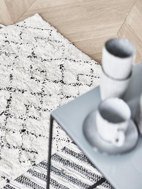 Tapis monochrome et table d'appoint en métal avec vaisselle rustique