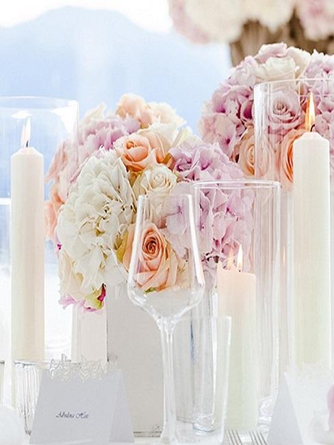 fleurs-décoration-mariage-table-couleurs pastel Décoration de table de mariage avec une composition des fleurs couleur blanc et pastel, des bougies blanches et un verre à vin