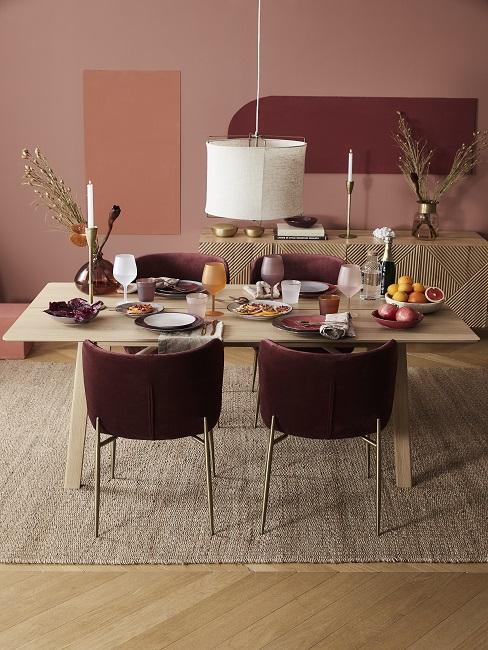 Wandfarbe Terracotta kombinieren im Esszimmer mit bordeauxroten Stühlen, Holztisch und Juteteppich