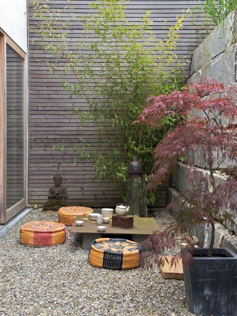 Jardin zen Jardin style zen avec table basse en bois et coussins de sol de couleurs différentes