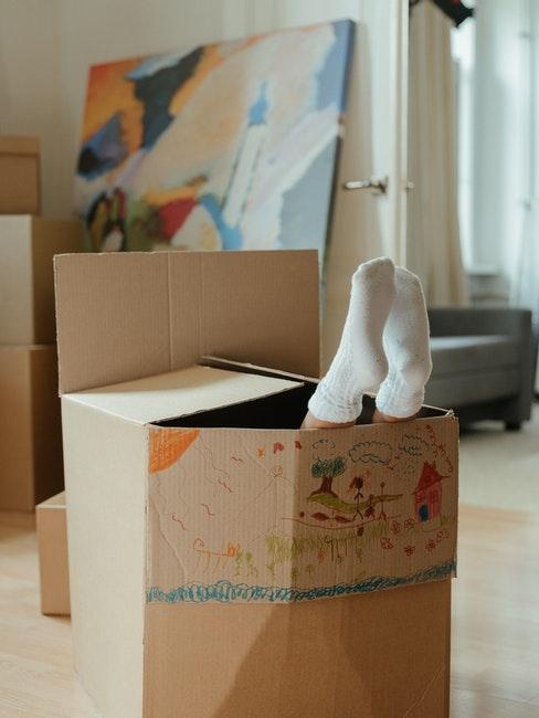 meubles-carton enfant caché dans une boîte en carton coloriée