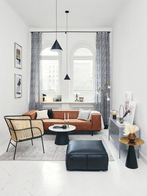 Oosters interieur header Oosters interieur woonkamer met rotan stoel en bruine leren bank en zwarte poef
