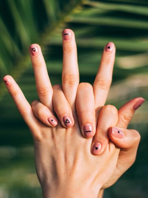 Manicure6 Twee handen ineen geslagen met nagellak en tekens op nagels